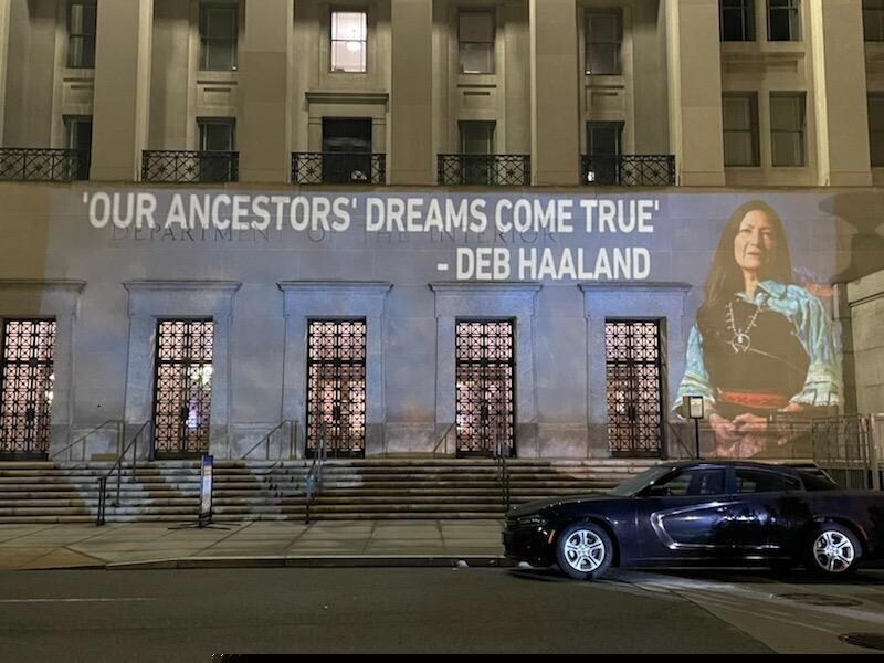 (Leah Salgado via AP) This photo provided by Leah Salgado shows the image of New Mexico U.S. Rep. Deb Haaland projected on the side of the U.S. Department of the Interior building in Washington, D.C., on Monday, Feb. 22, 2021. Native Americans will be closely watching a confirmation hearing Tuesday, Feb. 23, 2021, for Haaland, who has been nominated to lead the Interior Department. If confirmed, she would be the first Native American to lead the agency that has broad oversight of tribal affairs and energy development.