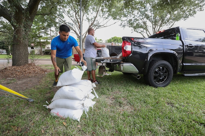 (Steve Gonzales | Houston Chronicle)  Albert Martinez and Victor Valerio fill bags with dirt from a pickup Thursday, Aug. 24, 2017, in Houston. Tropical Storm Harvey intensified Thursday into a hurricane that forecasters said would be the first major hurricane to hit Texas in 12 years.