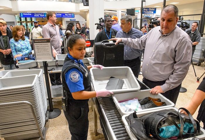 (Steve Griffin  |  The Salt Lake Tribune)  TSA agent Joyce Domingo helps airline passengers as they go through security at Salt Lake International Airport Thursday October 5, 2017. TSA has implemented stronger carry-on baggage screening for electronic devices where any electronic device larger than a cell phone needs to be in bins for X-ray.