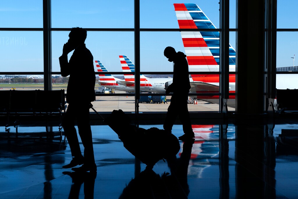 Travelers walk to and from their planes at Ronald Reagan Washington National Airport, Tuesday, Nov. 24, 2020, in Arlington, Va. (AP Photo/Jacquelyn Martin)
