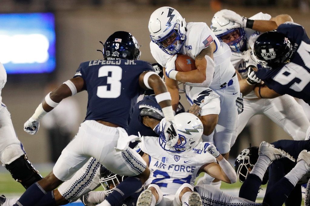 Air Force fullback Timothy Jackson, center, runs for a short gain as Utah State safety Troy Lefeged Jr., left, and defensive tackle Caden Andersen come in to make the stop in the first half of an NCAA college football game Saturday, Oct. 26, 2019, at Air Force Academy, Colo. Lefeged last week had shoulder surgery that will end his 2020 season. (AP File Photo/David Zalubowski)