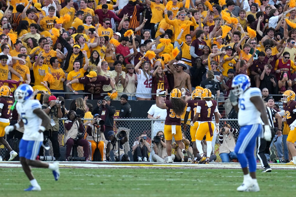 BYU players walk off the field as Arizona State fans and players celebrate an interception during the second half of an NCAA college football game Saturday, Nov. 23, 2024, in Tempe, Ariz. Arizona State won 28-23. (AP Photo/Ross D. Franklin)