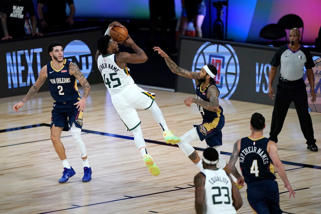 Utah Jazz's Donovan Mitchell (45) shoots as teammate Royce O'Neale (23) watches along with New Orleans Pelicans' Lonzo Ball (2), Brandon Ingram and JJ Redick (4) during the second half of an NBA basketball game Thursday, July 30, 2020, in Lake Buena Vista, Fla. (AP Photo/Ashley Landis, Pool)