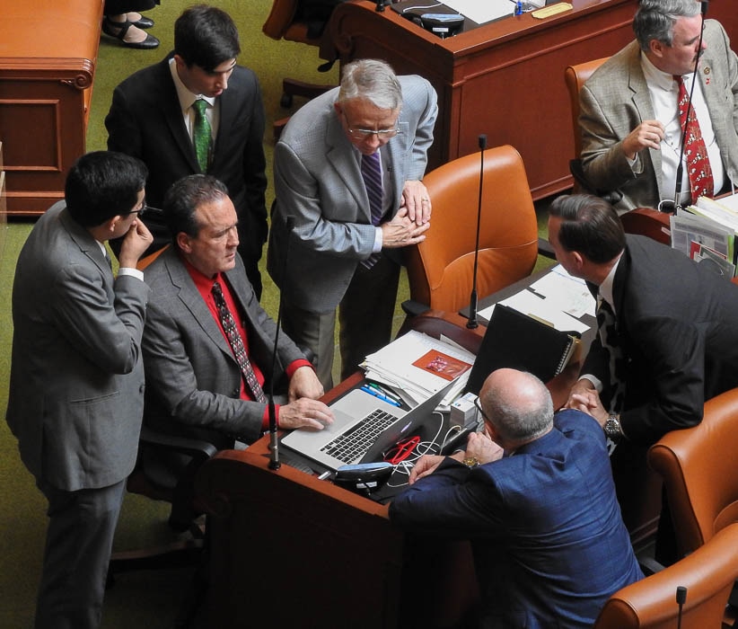 (Trent Nelson | Tribune file photo)   Legislators and staff surround Rep. Brad Daw, R-Orem, on the House floor, Feb. 9, 2018.