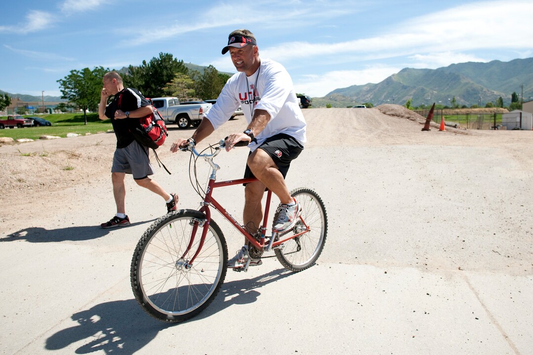 (Chris Detrick | The Salt Lake Tribune) Kyle Whittingham after rides his bike after a fall practice in 2011.