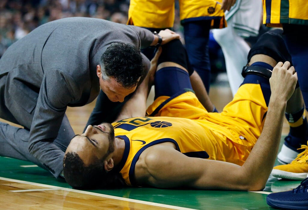 Utah Jazz's Rudy Gobert lies on the court after being injured during the first quarter of an NBA basketball game against the Boston Celtics in Boston, Friday, Dec. 15, 2017. (AP Photo/Michael Dwyer)