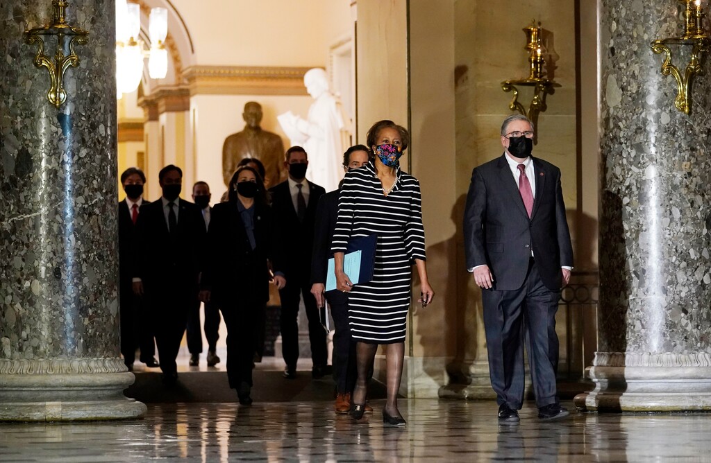 Clerk of the House Cheryl Johnson along with acting House Sergeant-at-Arms Tim Blodgett, lead the Democratic House impeachment managers as they walk through Statuary Hall in the Capitol, to deliver to the Senate the article of impeachment alleging incitement of insurrection against former President Donald Trump, Monday, Jan. 25, 2021 in Washington. (AP Photo/Susan Walsh)