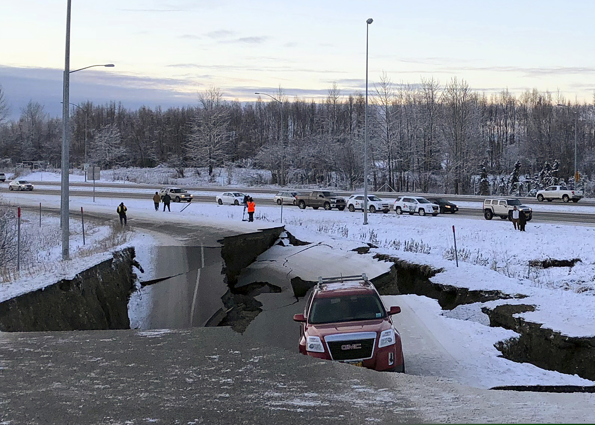 (Dan Joling | AP Photo) A car is trapped on a collapsed section of the offramp of Minnesota Drive in Anchorage, Friday, Nov. 30, 2018. Back-to-back earthquakes measuring 7.0 and 5.8 rocked buildings and buckled roads Friday morning in Anchorage, prompting people to run from their offices or seek shelter under office desks, while a tsunami warning had some seeking higher ground.
