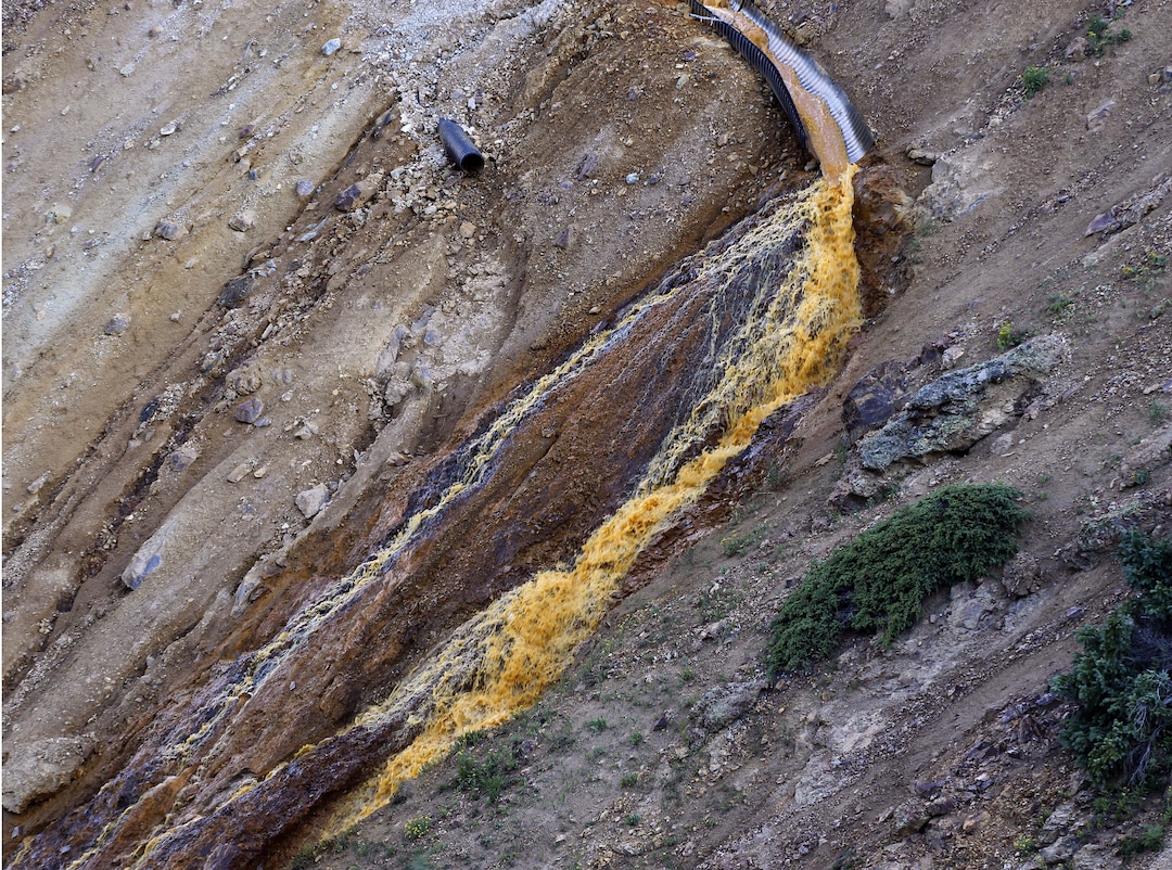 Wastewater flows from a trough and down a steep ravine at the site of the blowout at the Gold King mine which triggered a major spill of toxic wastewater, outside Silverton, Colo., Thursday, Aug. 13, 2015. It will take years, if not decades, and many millions of dollars to clean up and manage the toxic wastewater from a this Colorado mine that unleashed a 100-mile-long torrent of heavy metals, affecting the livelihoods of residents in three states, according to some experts. (AP Photo/Brennan Linsley)