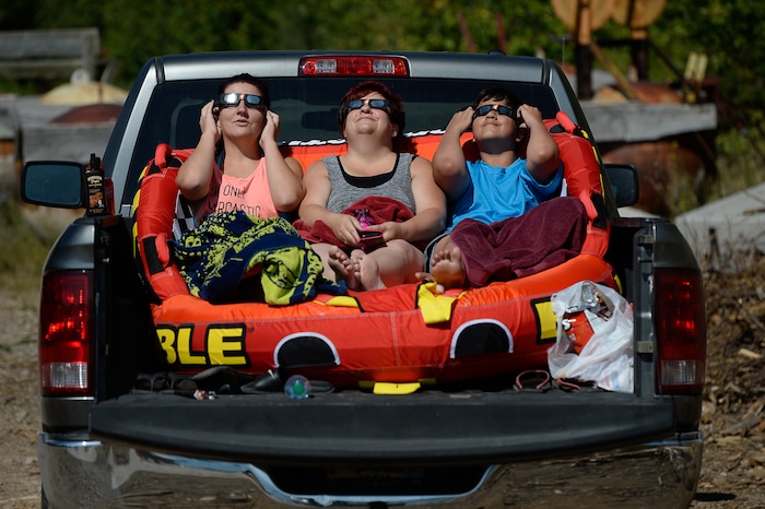 (Francisco Kjolseth  |  The Salt Lake Tribune)  McKeal Borresen, and Tamie Luchetta, alongside her son Chris, 12, from left, enjoy the total eclipse of the sun from the comfort of their truck bed at Palisades Reservoir, Idaho, on Monday, August 21, 2017.