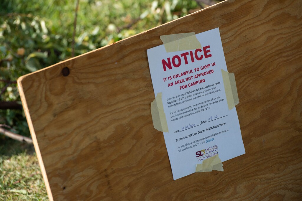 (Francisco Kjolseth | The Salt Lake Tribune) The Salt Lake County Health Department posts a notice at a homeless camp along 400 East near 700 South with plans to remove and clean up their camp on Thursday, Sept. 10, 2020.