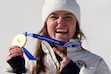 (Andy Wong | AP) United States' Breezy Johnson shows her gold medal in the alpine ski women's downhill race, at the 2026 Winter Olympics, in Cortina d'Ampezzo, Italy, Sunday, Feb. 8, 2026.