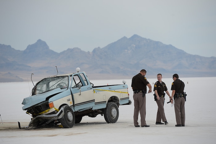 (Francisco Kjolseth | The Salt Lake Tribune) Highway patrol investigate the scene of a deadly crash at Utah's Bonneville Salt Flats along the sidelines of Speed Week following a head-on collision between two vehicles carrying support crew traveling between the pits and the entrance to the salt along the access road on Wednesday, Aug. 16, 2017. One person was killed and five injured, all of whom were said to be members of support crews for racing drivers.
