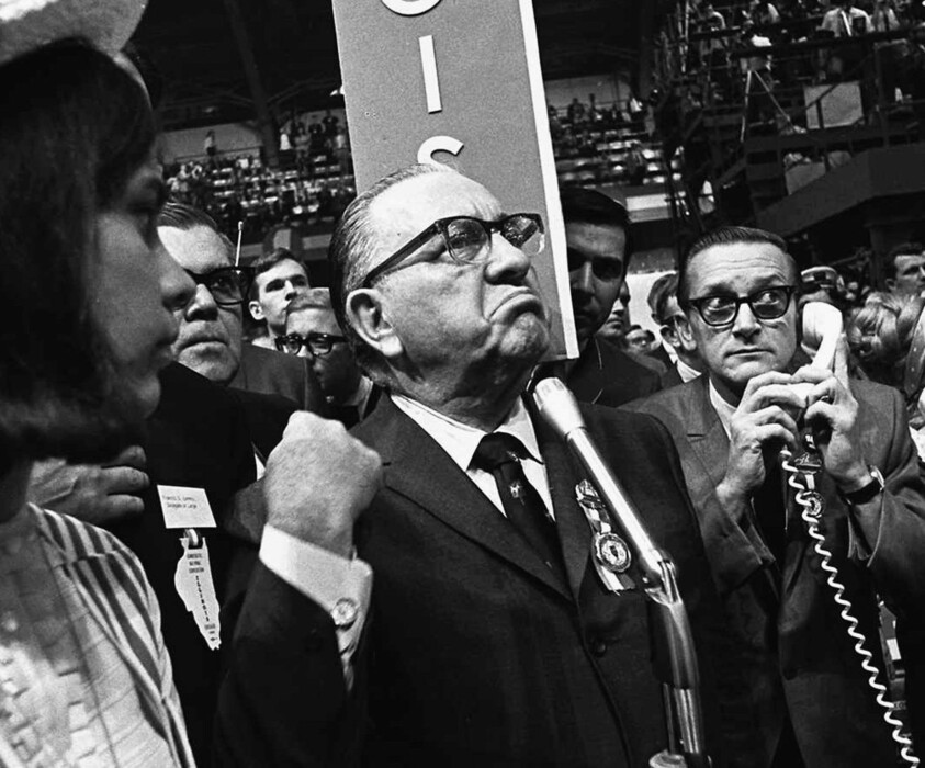 FILE - In this Aug. 28, 1968, file photo, Mayor Richard J. Daley stands at the microphone as shouts resound through the International Amphitheatre in Chicago, demanding the Democratic National Convention adjourn until later in the day before considering the party platform. During the convention, hundreds of demonstrators waged war with police and National Guardsmen on the streets of Chicago. (AP Photo/Jack Thornell, File)