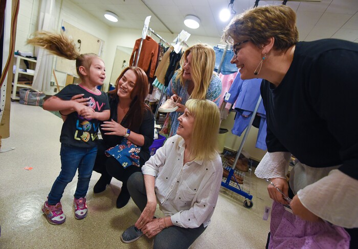 (Francisco Kjolseth  |  The Salt Lake Tribune)  Sovay Shenefelt, 3, jumps for joy as she is shown a costume piece with her favorite colors of purple and pink for the upcoming show of "Mamma Mia!" at Pioneer Theatre. The cast and crew have spent years juggling schedules to balance mothering and professional work, including Sovay's mother and actor Megan Shenefelt, actor Mary Fanning Driggs, director/choreographer Patricia Wilcox and costume designer Brenda Van der Wiel, from left. 