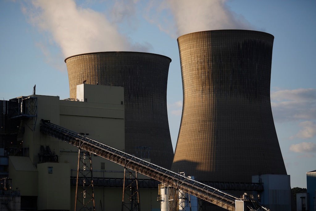 (Luke Sharrett | Bloomberg) Steam rises from cooling towers at the American Electric Power Co. coal-fired power plant in Winfield, W.Va., on July 18.