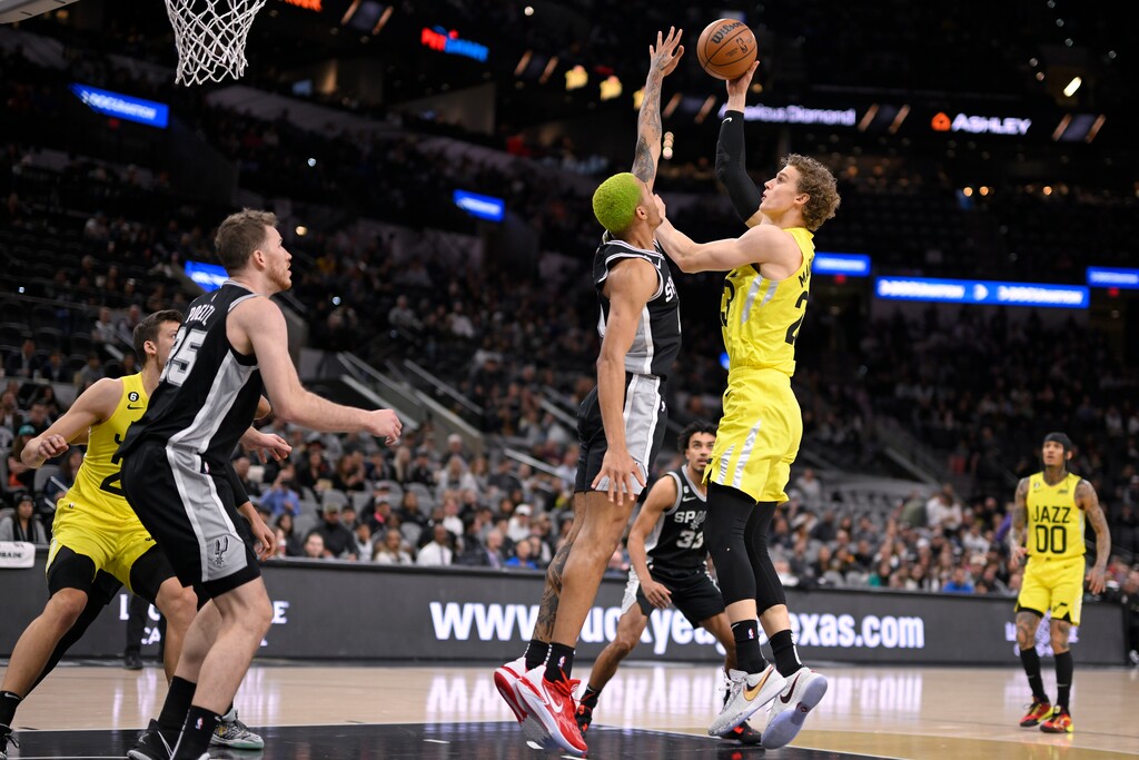 Utah Jazz's Lauri Markkanen, front right, shoots against San Antonio Spurs' Jeremy Sochan during the first half of an NBA basketball game, Monday, Dec. 26, 2022, in San Antonio. (AP Photo/Darren Abate)
