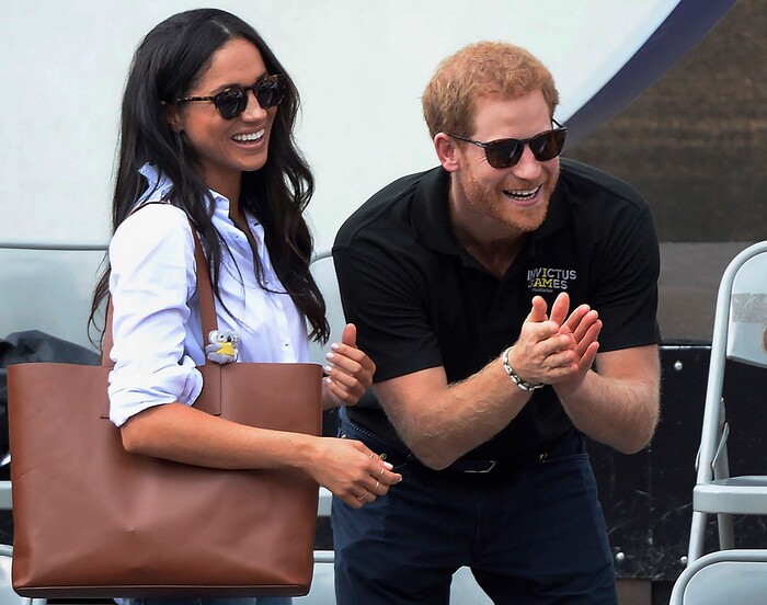 FILE - In this Monday, Sept. 25, 2017 file photo, Britain's Prince Harry and his girlfriend Meghan Markle attend the wheelchair tennis competition during the Invictus Games in Toronto. Palace officials announced Monday Nov. 27, 2017, Prince Harry and Meghan Markle are engaged, and will marry in the spring. (Nathan Denette/The Canadian Press via AP, File)