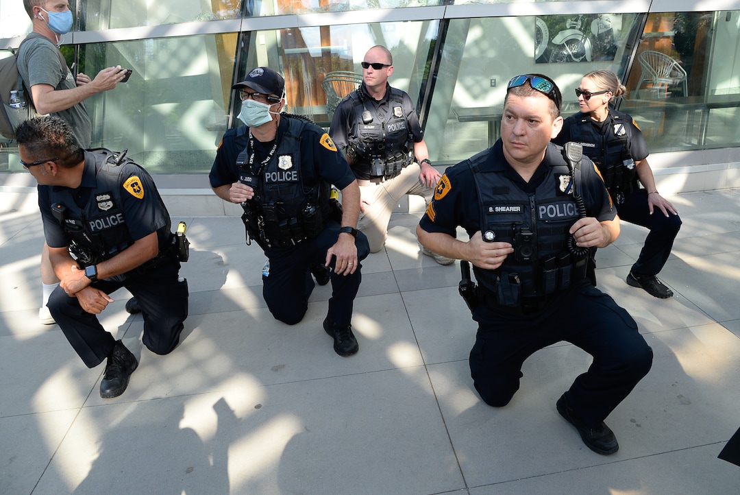 (Francisco Kjolseth  |  The Salt Lake Tribune) Salt Lake City officers take a knee as toe show his support of demonstrators protesting against police brutality on Wednesday, June 3, 2020, in downtown Salt Lake City, at the Salt Lake City Public Safety Building as the initially set 8 p.m. weeklong curfew was removed.
