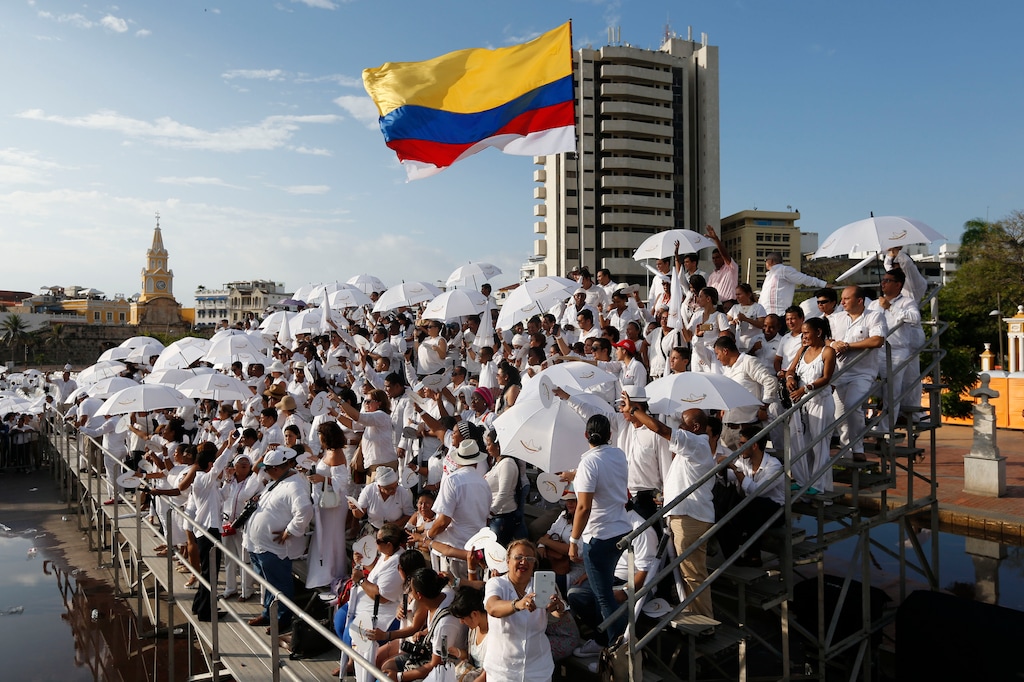 People wait for the start of the peace ceremony before the signing of a peace agreement between Colombia’s government and the Revolutionary Armed Forces of Colombia, FARC, in Cartagena, Colombia, Monday, Sept. 26, 2016. (AP Photo/Fernando Vergara)