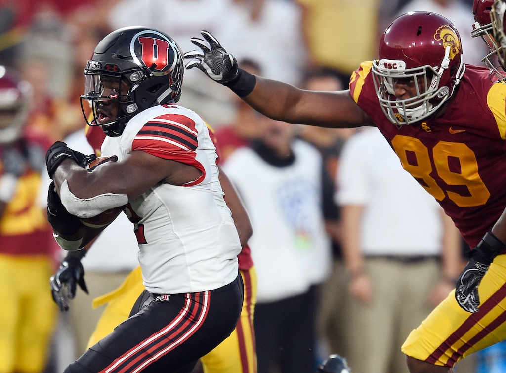 Utah running back Zack Moss, left, runs the ball ahead of Southern California defensive lineman Christian Rector during the first half of an NCAA college football game in Los Angeles, Saturday, Oct. 14, 2017. (AP Photo/Kelvin Kuo)