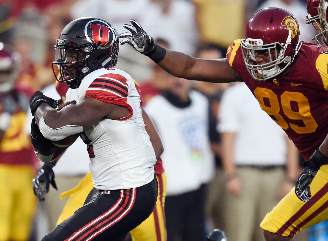 Utah running back Zack Moss, left, runs the ball ahead of Southern California defensive lineman Christian Rector during the first half of an NCAA college football game in Los Angeles, Saturday, Oct. 14, 2017. (AP Photo/Kelvin Kuo)