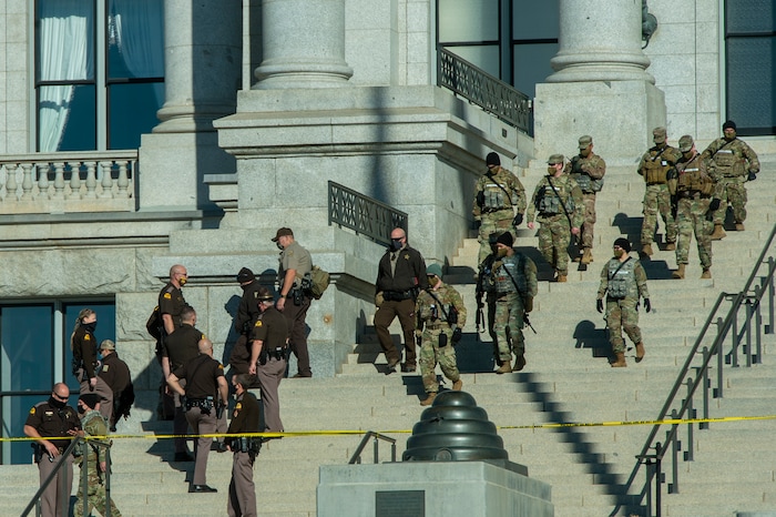 (Rick Egan | The Salt Lake Tribune)  Hundreds of National Guardsmen highway patrol and other security come down the stairs of the state Capitol where a dozen protesters gathered on Sunday, Jan. 17, 2021.