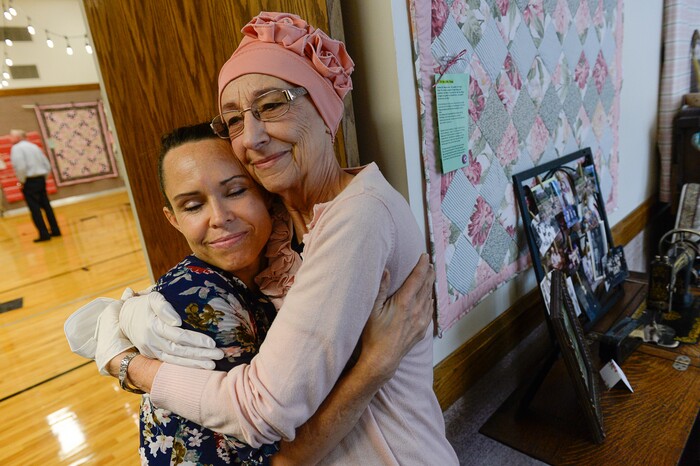(Francisco Kjolseth  |  The Salt Lake Tribune)  Dar Willes is embraced by her mother Nacele Hart during a special show of more than 100 quilts and numerous sewing projects created by Nacele over a 10-year period for her children, grandchildren and great-grandchildren. On Friday at a church in Orem her family put them on display with plans to hand them out Saturday to her loved ones. She's also currently battling cancer.