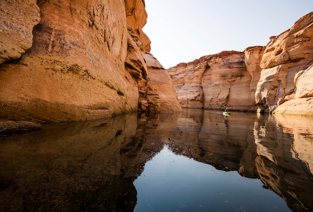 (Rick Egan | The Salt Lake Tribune)  A woman paddles a Kayak down Antelope Canyon, on Wednesday, Aug. 4, 2021. Water levels are dropping a few inches a day, which may bring an early end to kayaking in Glen Canyon in the next week or so, shortening a season that usually goes through the end of October.