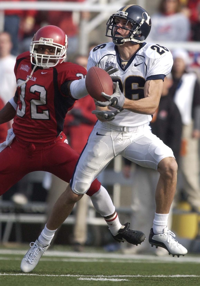 (Trent Nelson  |  Tribune file photo)  BYU receiver Rod Wilkerson catches the ball in front of Utah defender D'Shaun Crockett during the Utah vs. BYU game on Saturday November 23, 2002, at Rice-Eccles Stadium.