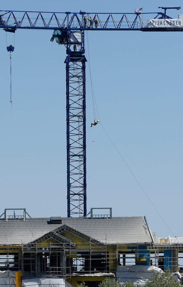 (Scott Sommerdorf | The Salt Lake Tribune) A firefighter with the Park City Fire District is lowered to the ground from the top of the 200-foot Jacobsen tower crane as the department conducts a high mountain rescue training exercise utilizing a Jacobsen tower crane at site of the One Empire Pass development at Deer Valley, Sunday, Aug. 20, 2017.