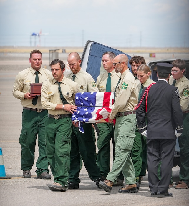 (Chris Samuels | The Salt Lake Tribune) Members of the U.S. Forest Service carry the casket and remains of two helicopter pilots at Salt Lake City International Airport, Friday, Aug. 14, 2026, during a ceremony to escort the pilots, who died while working on the Widemouth 2 Fire near Fillmore on Aug. 7.