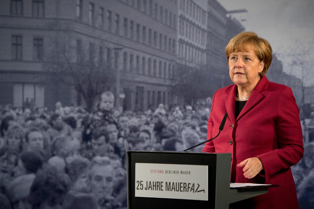 German Chancellor Angela Merkel delivers a speech in front of a historical photograph in the Berlin Wall memorial at Bernauer Strasse in Berlin, Germany, Sunday, Nov. 9, 2014. 25 years ago - on Nov. 9, 1989 - the East-German government lifted travel restrictions and thousands of East Berliners had pushed their way past perplexed border guards to celebrate freedom with their brethren in the West. (AP Photo/dpa, Soeren Stache)