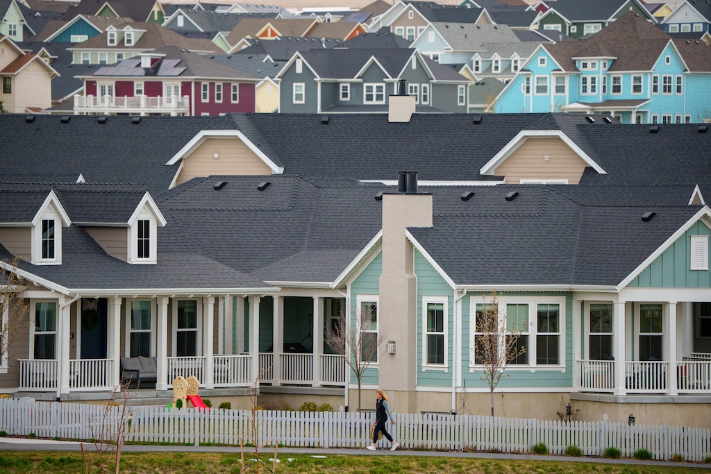 (Trent Nelson  |  The Salt Lake Tribune) A person walks along a path in Daybreak, in South Jordan, on Thursday, April 4, 2024. The master-planned community has its critics, but residents say they keep finding reasons to stay.