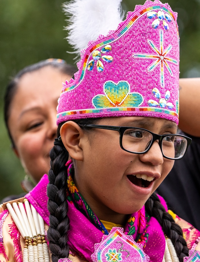 (Leah Hogsten | The Salt Lake Tribune Cedar Redfoot, winces as Sabrina Redfoot cinches a feather in the headband of her jingle ceremonial dress at the 41st Annual Paiute Indian Tribe of Utah Restoration Gathering, Aug. 13, 2021 in Cedar City, Utah.