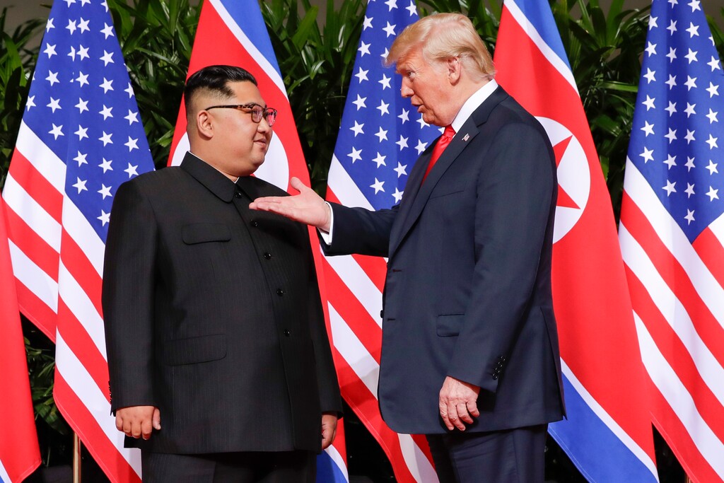 (AP Photo/Evan Vucci) U. S. President Donald Trump gestures toward the meeting site with North Korea leader Kim Jong Un at the Capella resort on Sentosa Island Tuesday, June 12, 2018 in Singapore.