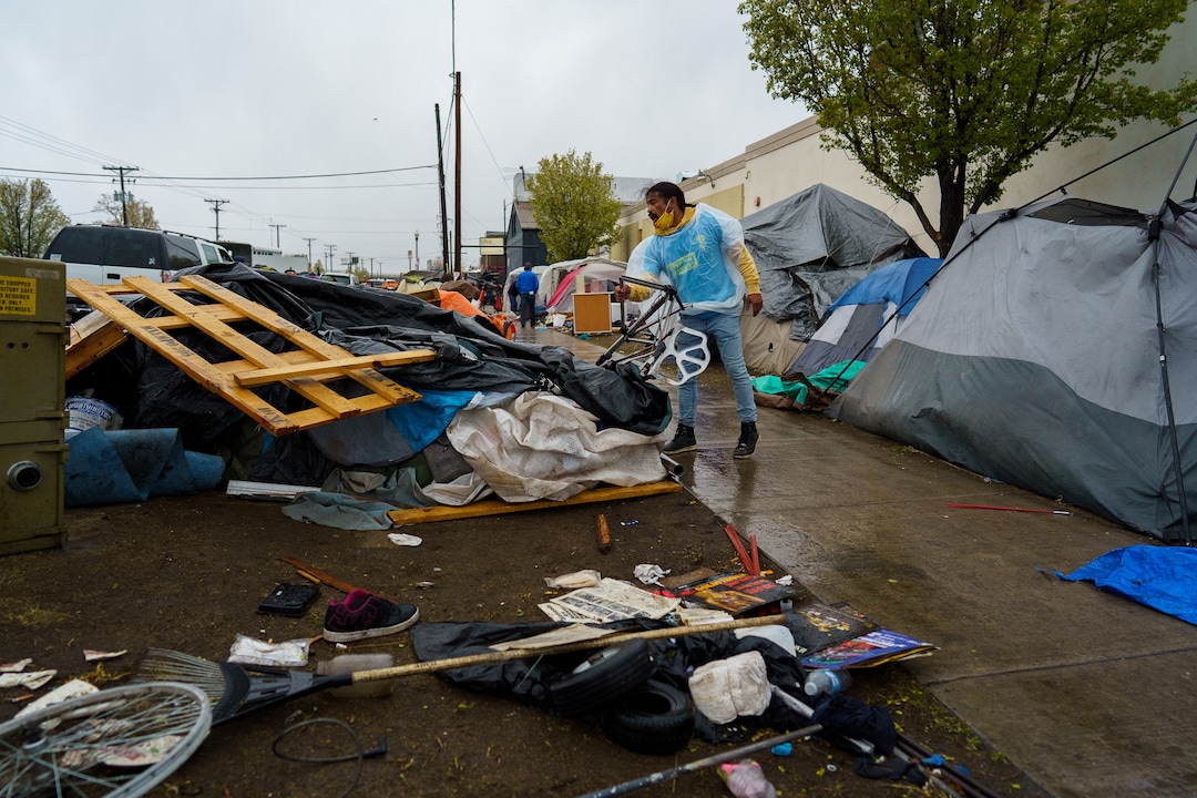 (Trent Nelson  |  The Salt Lake Tribune) Carl Moore helps people move their belongings as Salt Lake County conducts a camp cleanup at the Fleet Block Murals in Salt Lake City on Wednesday, April 14, 2021.
