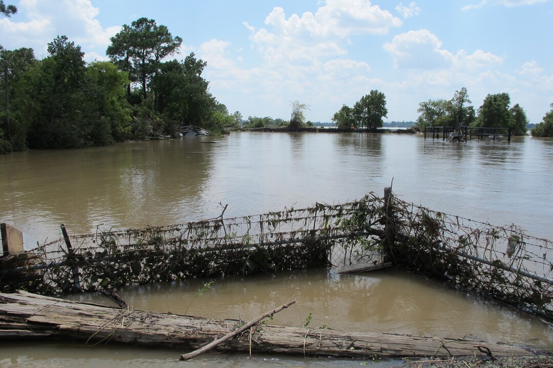 FILE - In this Aug. 31, 2017 file photo, a barbed-wire fence encircles the Highlands Acid Pit that was flooded by water from the nearby San Jacinto River as a result from Harvey in Highlands, Texas.  Floodwaters have inundated at least five highly contaminated toxic waste sites near Houston, raising concerns that the pollution there might spread. (AP Photo/Jason Dearen)