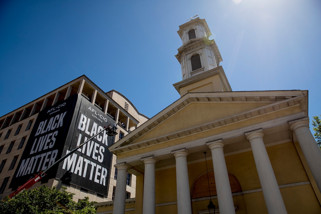 (Andrew Harnik | AP file photo) St. John's Episcopal Church next to a large "Black Lives Matter" banner on the AFL-CIO building near the White House in Washington, Friday, June 12, 2020. In 2020, mainline Protestant denominations, including the Episcopal, United Methodist and Presbyterian-USA churches, are now deeply engaged in campaigns against racism and voter suppression.