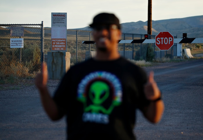 (John Locher | AP Photo) In this July 22, 2019 photo, Stan Evans poses as he has his picture taken while visiting an entrance to the Nevada Test and Training Range near Area 51 outside of Rachel, Nev. The U.S. Air Force has warned people against participating in an internet joke suggesting a large crowd of people "storm Area 51," the top-secret Cold War test site in the Nevada desert.