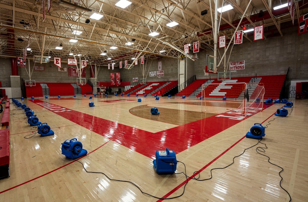 (Rick Egan | The Salt Lake Tribune) Fans dry the floor of the East High gymnasium after heavy rains flooded parts of the building last night, on Monday, Aug. 2, 2021.