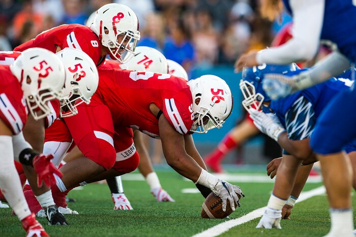 (Chris Detrick  |  The Salt Lake Tribune)  East's Seni Tuiaki (56) gets ready to hike the ball to East's Ben Ford (8) during the game at Bingham High School Friday, August 25, 2017. Bingham is winning the game 24-17 at halftime. 