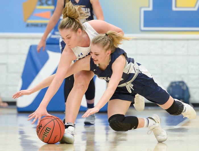 (Leah Hogsten  |  The Salt Lake Tribune) Bingham's Maggie Mccord (15) and Copper Hills' Amberly Lazenby (01) scramble for a loose ball.  Bingham faces Copper Hills in their semifinal game of the 6A High School Girls' Basketball Tournament at SLCC in Taylorsville, Friday, Feb. 23, 2018. 