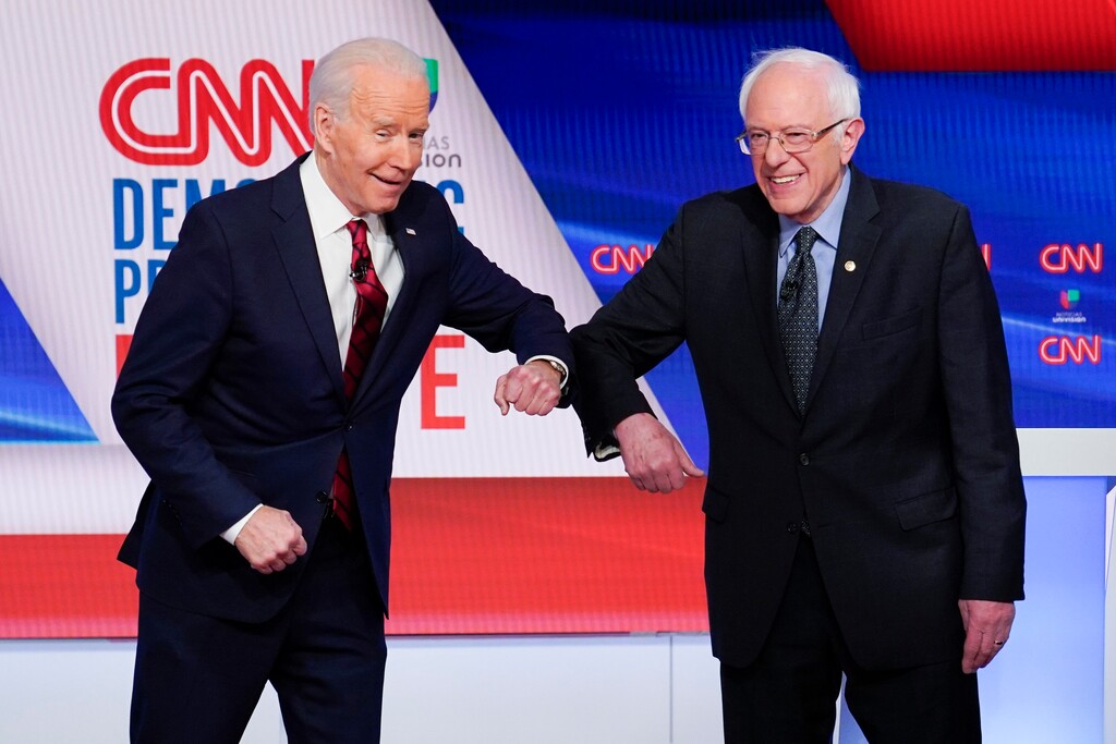 (Evan Vucci | AP)  Former Vice President Joe Biden, left, and Sen. Bernie Sanders, I-Vt., right, greet each other before they participate in a Democratic presidential primary debate at CNN Studios in Washington, Sunday, March 15, 2020.
