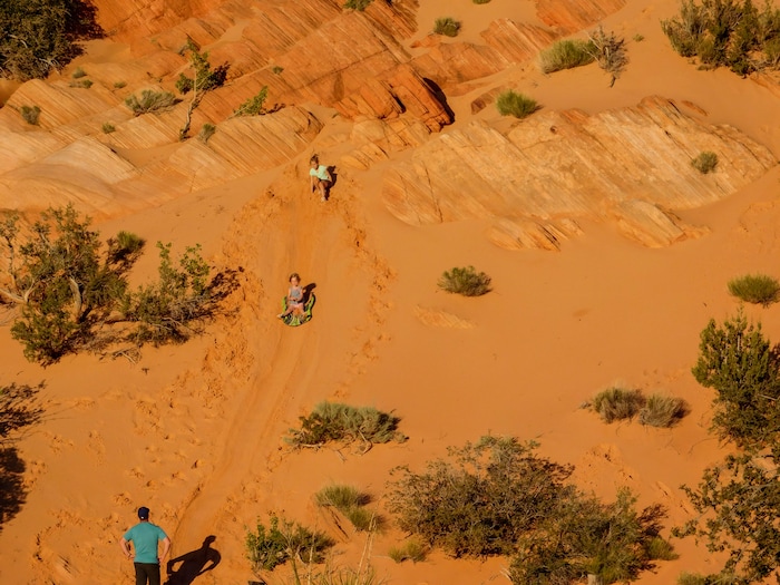 Erin Alberty  |  The Salt Lake Tribune

A family sleds down a sandy slope in the Sand Cove campground April 1, 2017 in the Red Cliffs Desert Reserve near Leeds.