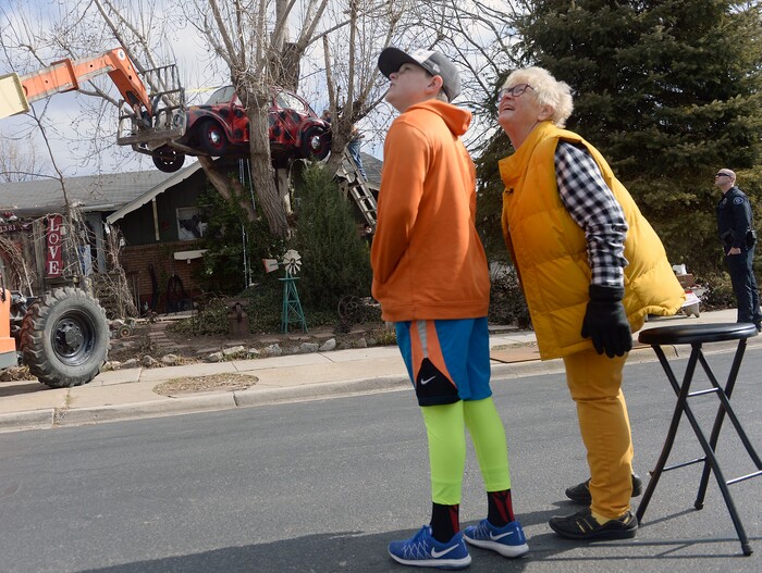 (Al Hartmann | The Salt Lake Tribune)
Clearfield public works personnel use a crane to remove Janis Zettel's gutted VW Beetle from a tree in her front yard Tuesday Feb. 13. She put it up a few months ago as an art installation. Now it has to come down. Zettel watches the operation with her grandson Fischer Grant from the street.
