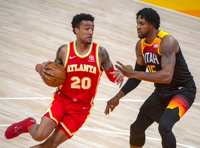(Rick Egan | The Salt Lake Tribune) Atlanta Hawks forward John Collins (20) drives up the middle, as Utah Jazz center Derrick Favors (15) defends, in NBA action between the Utah Jazz and the Atlanta Hawks at Vivint Arena, on Friday, Jan. 15, 2021.