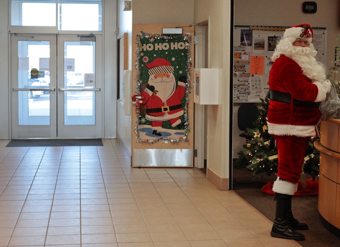 Bus driver Don Fitch delivers candy canes to other Alpine School District transportation staff on Tuesday, Dec. 19, 2017 in American Fork, Utah.  Fitch has driven school buses for the Alpine School District for the past four years. Every year around Christmas, he decorates the bus’s interior with Christmas decorations, plays Christmas music and dresses up as Santa.   (Evan Cobb /The Daily Herald via AP)