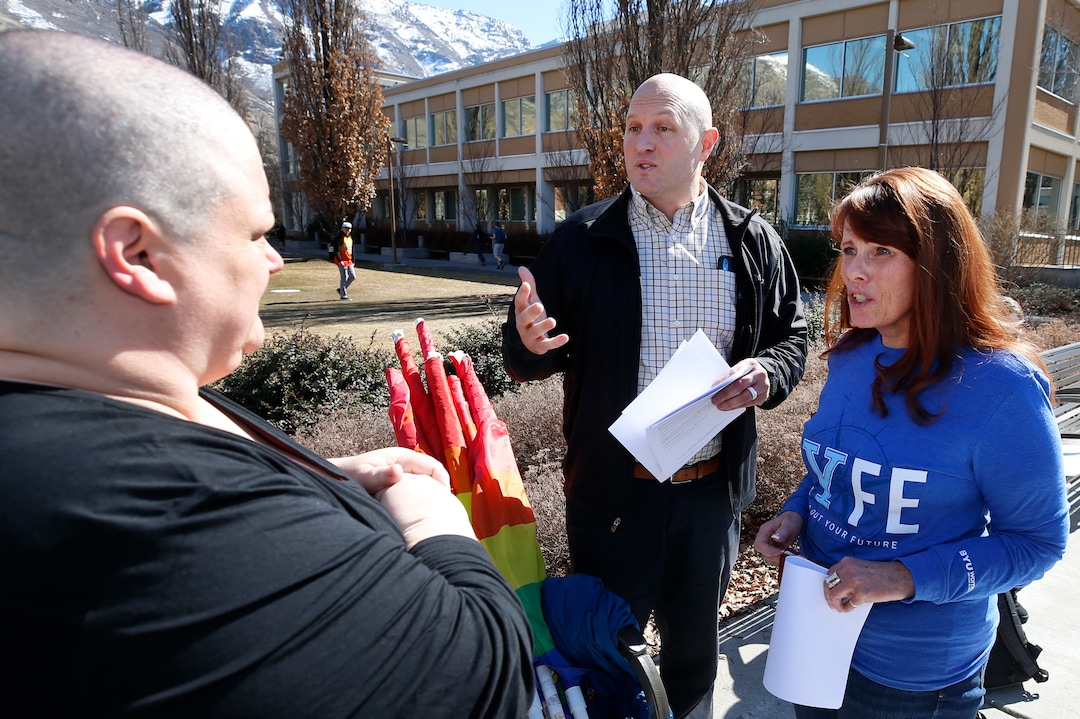 (George Frey  |  special to The Salt Lake Tribune) Two BYU officials from the ÒDean of Students OfficeÓ who refused to identify themselves, try to get protesters to go with them to fill out paper work for a protest in front of the Ernest L. Wilkinson Student Center on the campus of Brigham Young University of BYUÕs rollback of a newly announced policy change on LGBTQ students on March 5, 2020 in Provo, Utah.