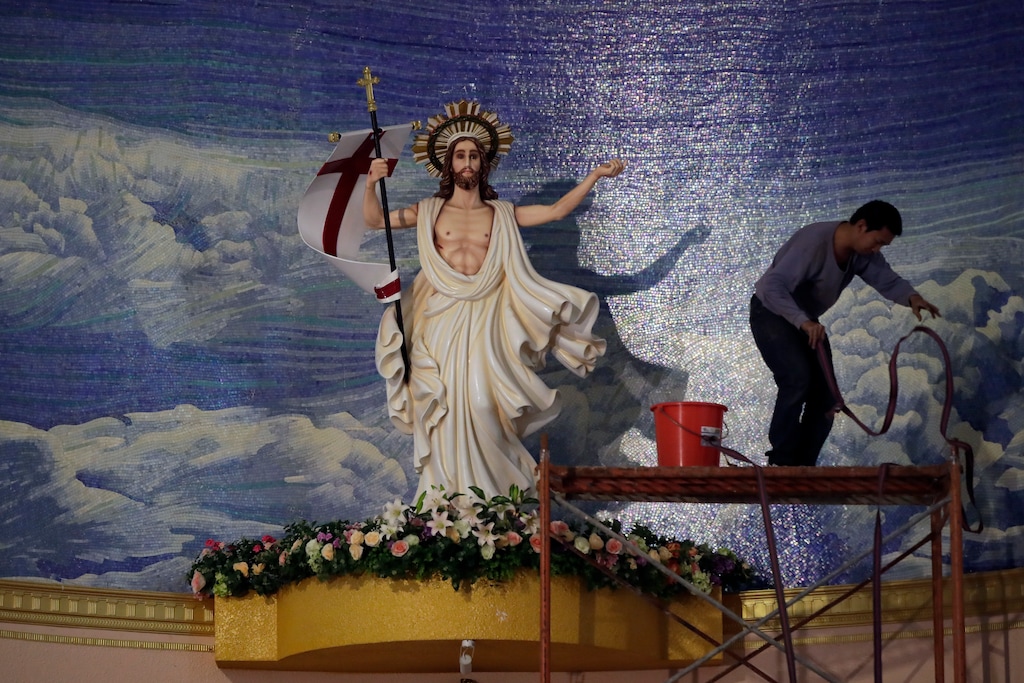 In this Wednesday, March 28, 2018 photo, a worker stands on a scaffolding as he preparing the up coming Easter day mass at the Shantou Catholic church in Shantou in south China's Guangdong province. Good Friday celebrations in one Chinese parish had a conspicuous absence: their bishop, who just the day before was whisked away by the government. The bishop is at the center of talks between the Vatican and the atheist Communist Party that are expected to yield a historic deal on who appoints bishops in China and unite the country’s Catholics for the first time since Beijing and the Holy See severed relations nearly seven decades ago. (AP Photo/Andy Wong)